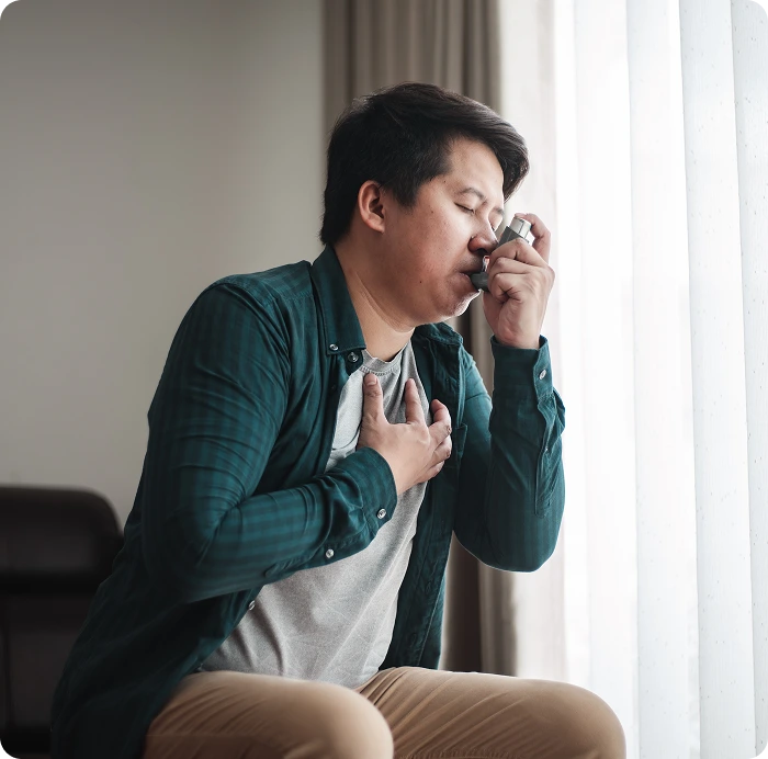 man struggling with asthma using an inhaler to breathe better