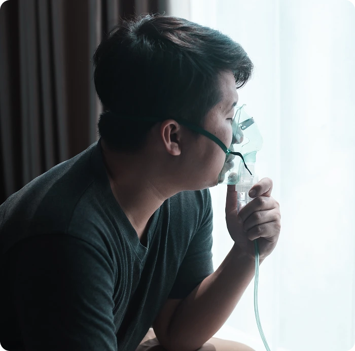 man struggling with copd using a nebulizer to breathe better