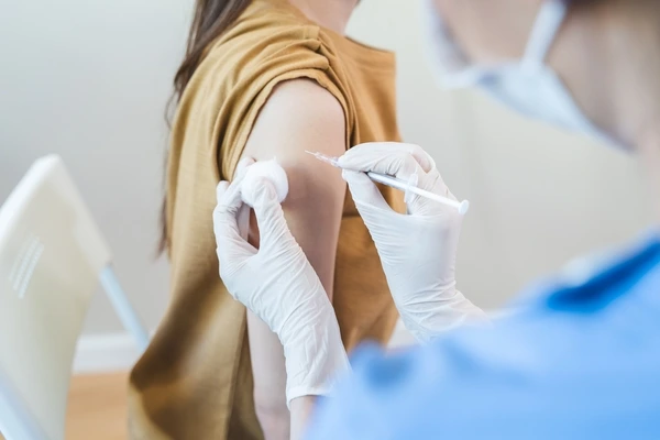 A kid getting a flu shot from a healthcare professional